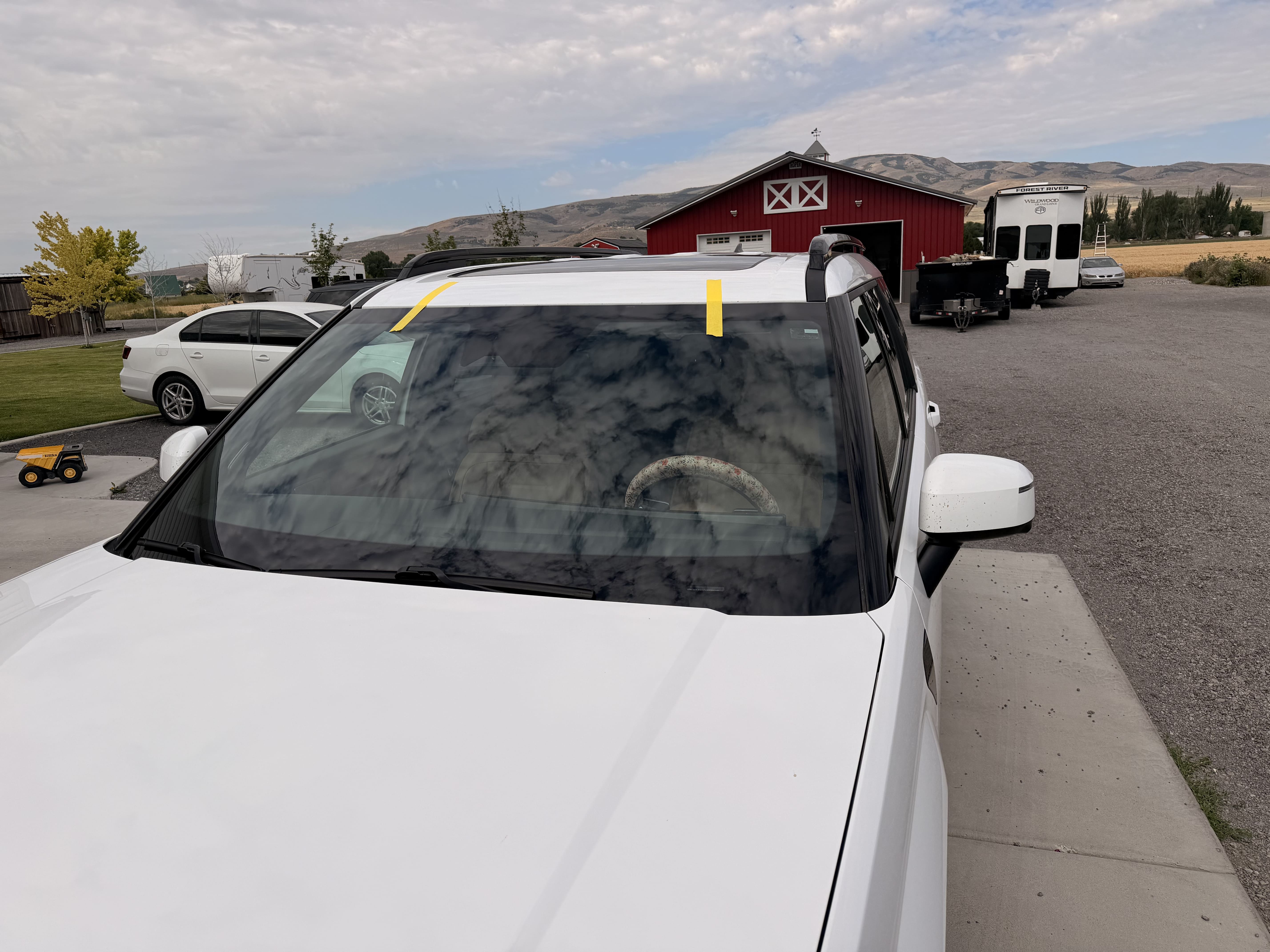 White SUV receiving windshield service outdoors